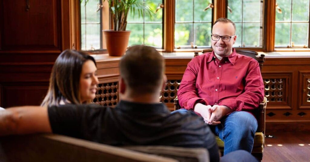 Dr. Mike, shown here consulting and laughing with a couple, shares how couples therapy can be a valuable resource for all relationship issues, including maintaining sex after kids.