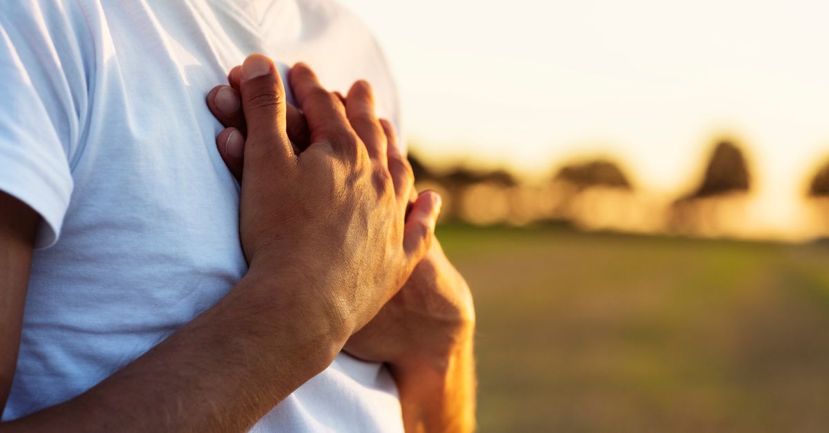 Man sits in mindfulness with his hands over his heart